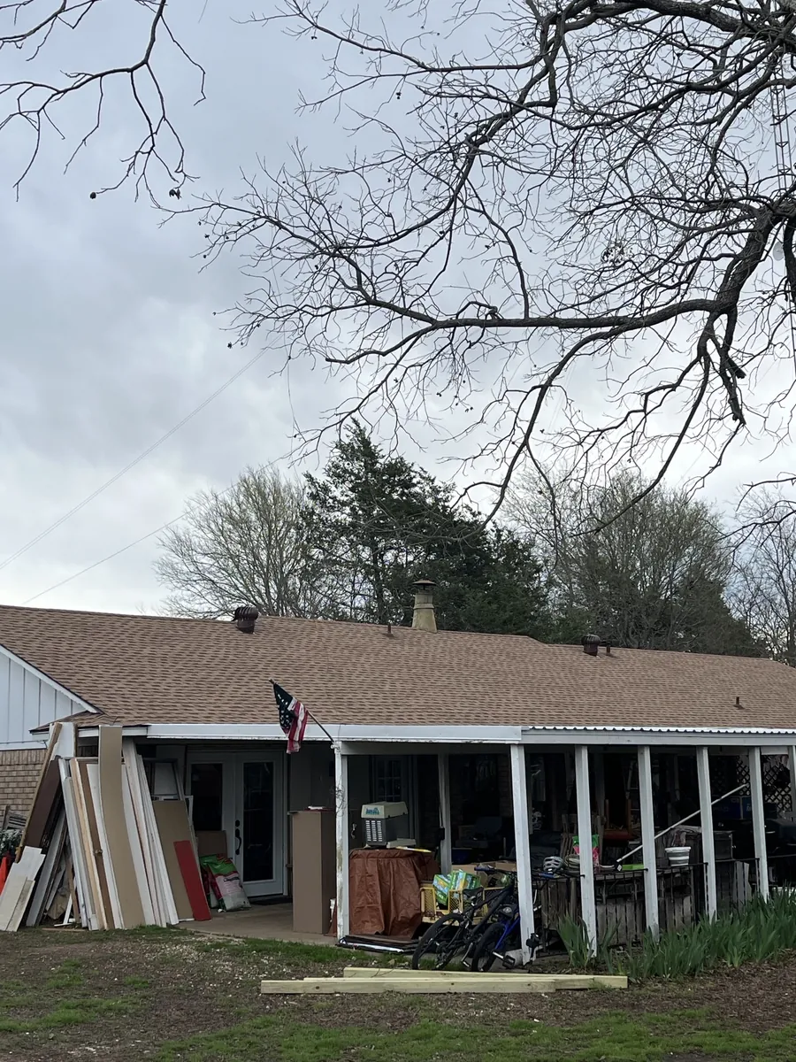 Side elevation of the Denison home with the finished shingle roof and porch